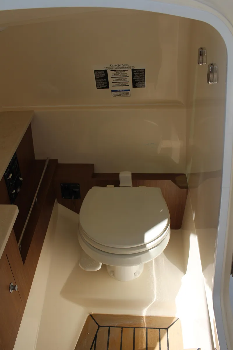 Slide: The Image of 2014 Boston Whaler 270 Vantage boat interior with compact marine toilet. - 17