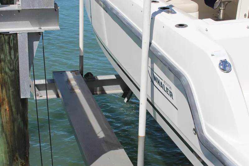Slide: The Image of 2014 Boston Whaler 270 Vantage on a boat lift over water. - 20
