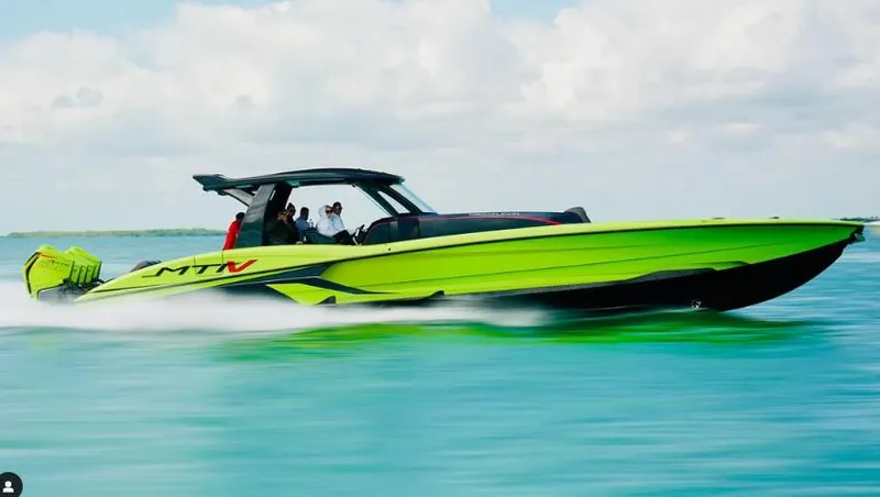 The Image of 2022 MTI 50V Center Console boat speeding on clear blue water. - 0