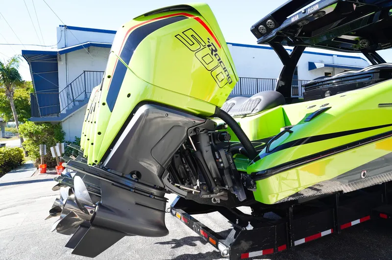 Slide: The Image of 2022 MTI 50V Center Console boat with vibrant green exterior and powerful outboard engine. - 34