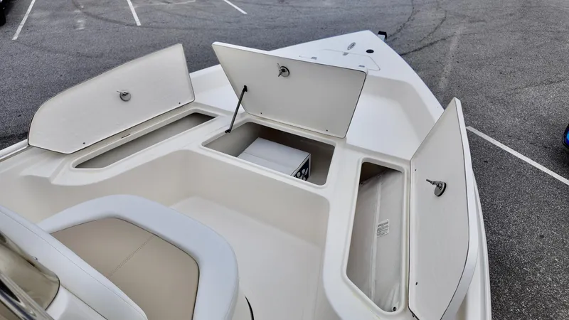 Slide: The Image of 2025 Bulls Bay 2000 boat with open storage compartments in a parking lot. - 12