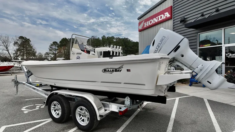 Slide: The Image of 2025 Bulls Bay 2000 boat on trailer outside Honda dealership. - 2