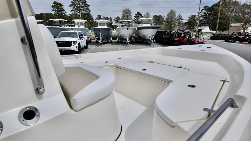 Slide: The Image of 2025 Bulls Bay 2000 boat interior with seating, parked in a lot with other vehicles. - 5