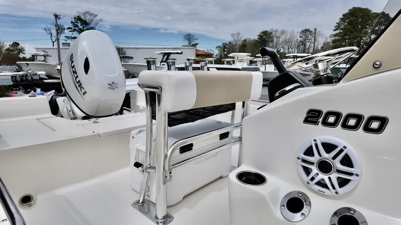 Slide: The Image of 2025 Bulls Bay 2000 boat interior with Suzuki engine, featuring seating and speaker system. - 7