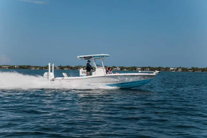 Slide: The Image of 2025 Caymas 28 HB boat cruising on open water under clear blue sky. - 0
