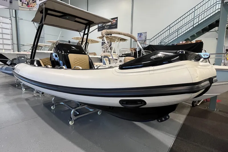The Image of 2025 Highfield Sport 520 inflatable boat displayed indoors on a showroom floor. - 0