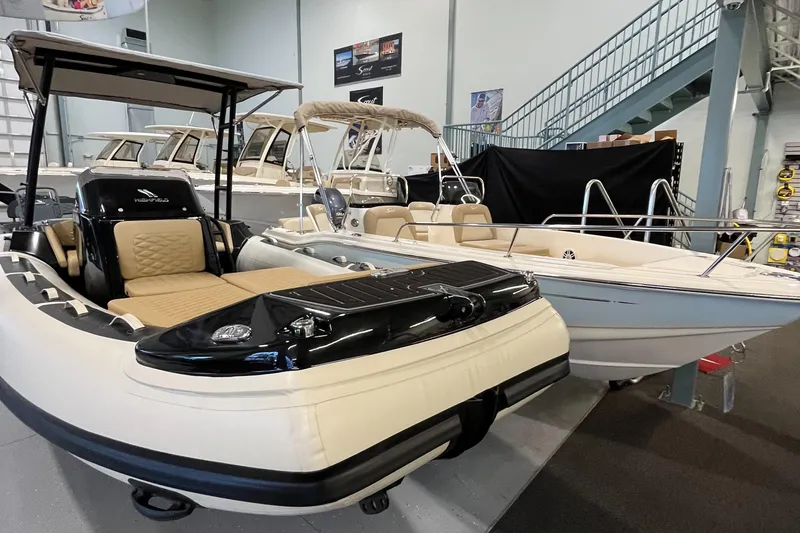 Slide: The Image of 2025 Highfield Sport 520 boat displayed in a showroom with other boats. - 2
