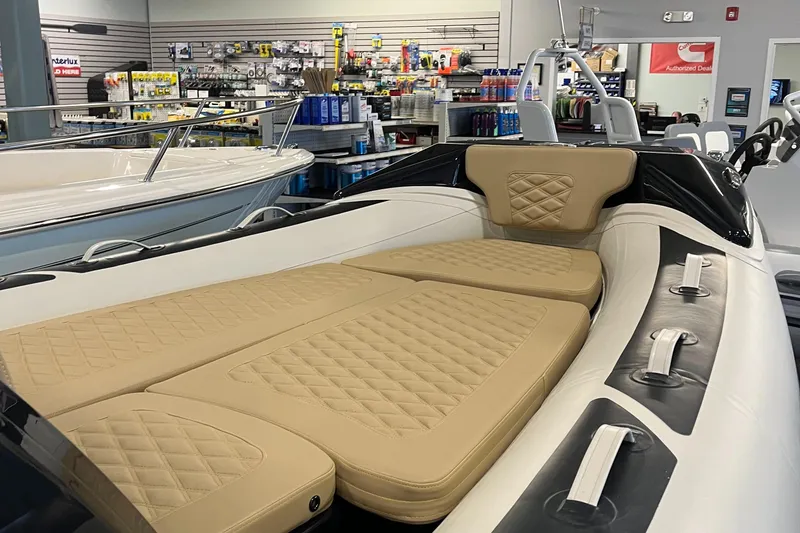 Slide: The Image of 2025 Highfield Sport 520 boat with beige quilted seating in a showroom. - 3