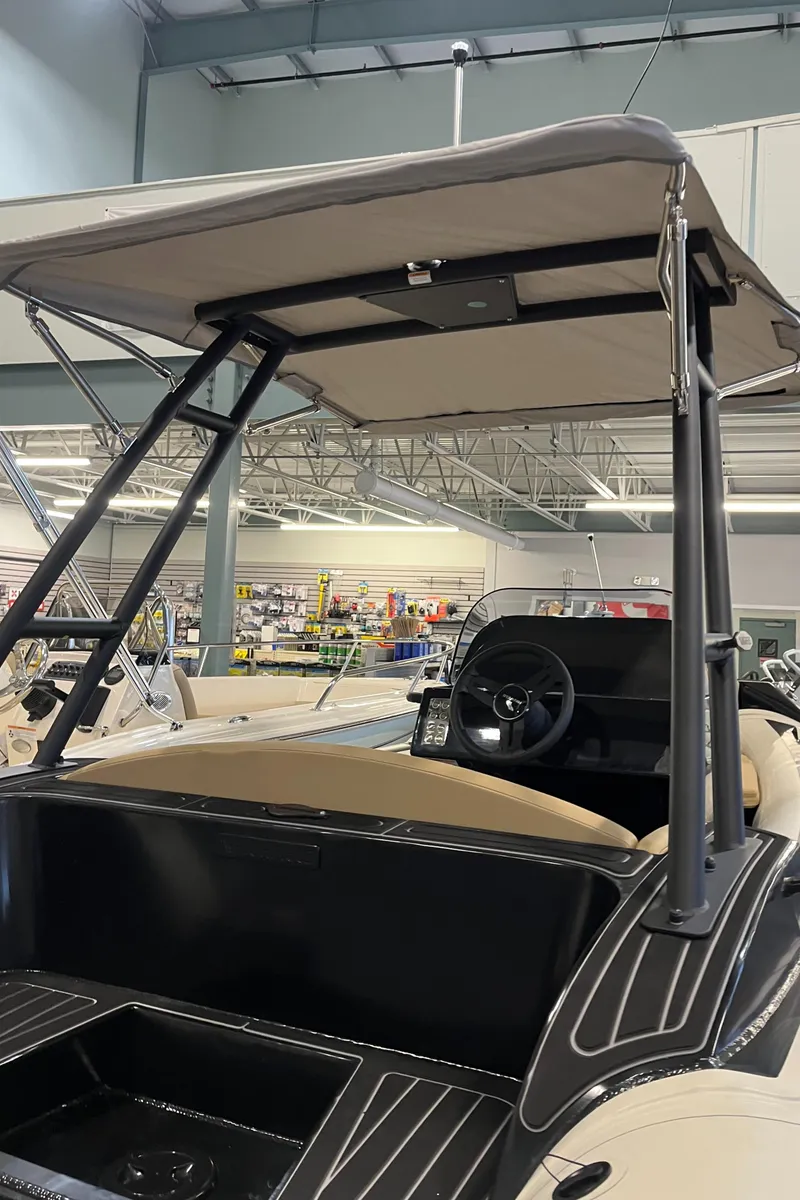 Slide: The Image of 2025 Highfield Sport 520 boat interior with steering wheel and canopy in showroom. - 4