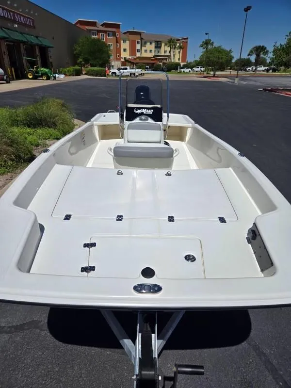 Slide: The Image of 2025 Mako Pro Skiff 17 CC boat, parked outdoors, showcasing spacious deck and seating. - 2