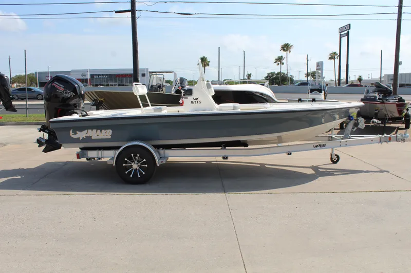 Slide: The Image of 2025 Mako 18 LTS boat on trailer, parked outdoors, side view. - 4