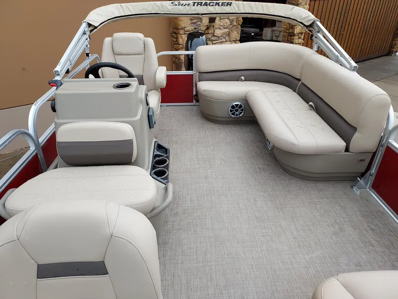 Slide: The Image of 2025 Sun Tracker Bass Buggy 16 XL Select pontoon boat with beige seating and spacious interior. - 2