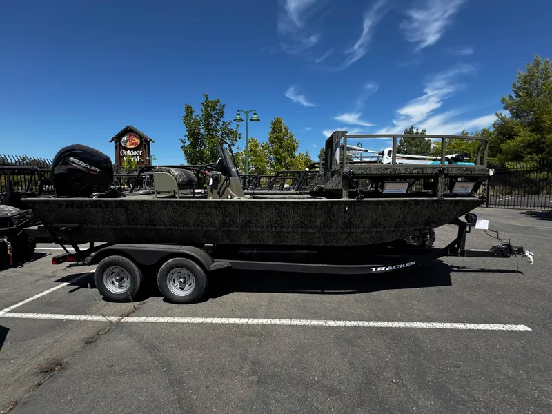 The Image of 2025 Tracker Grizzly 2072 CC Sportsman boat on trailer in parking lot. - 0