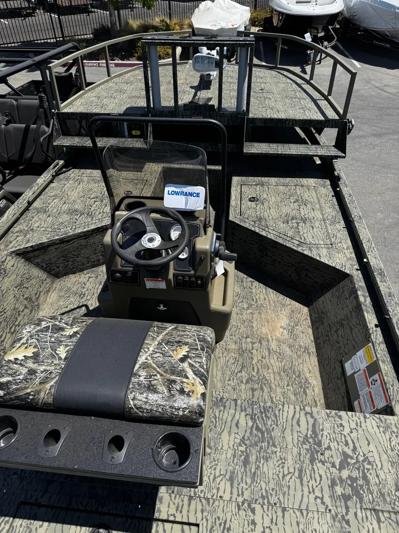 Slide: The Image of 2025 Tracker Grizzly 2072 CC Sportsman boat with camo design and steering console. - 3