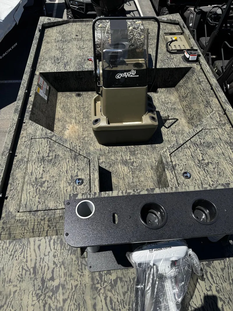 Slide: The Image of 2025 Tracker Grizzly 2072 CC Sportsman boat interior with camouflage design and console. - 6