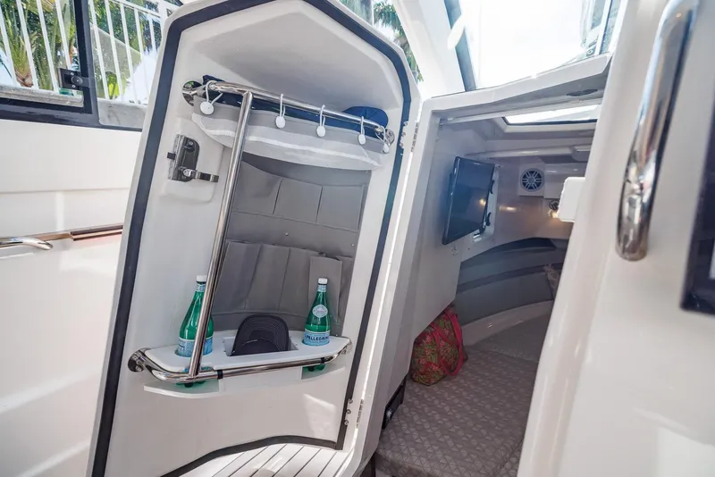 Slide: The Image of 2026 Solara S-310 Sport Bridge cabin interior with seating, storage, and bottled water. - 19