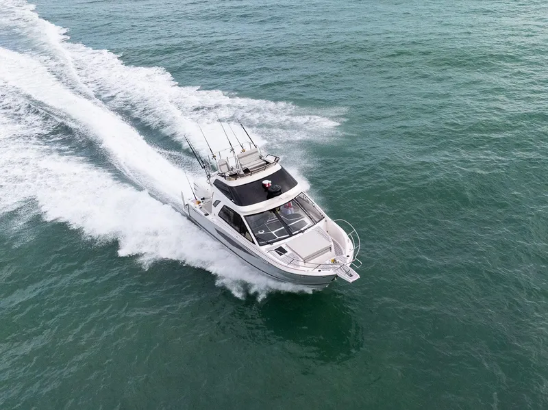 Slide: The Image of 2026 Solara S-310 Sport Bridge cruising on open water, aerial view. - 4