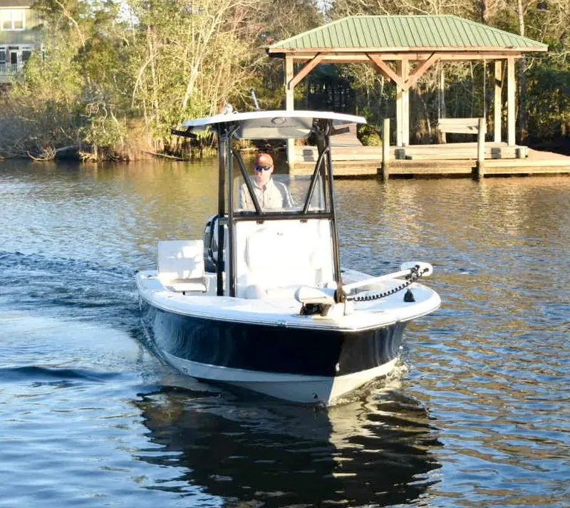 Slide: The Image of 2019 Sea Hunt BX 22 BR boat cruising near a wooden dock on a sunny day. - 4