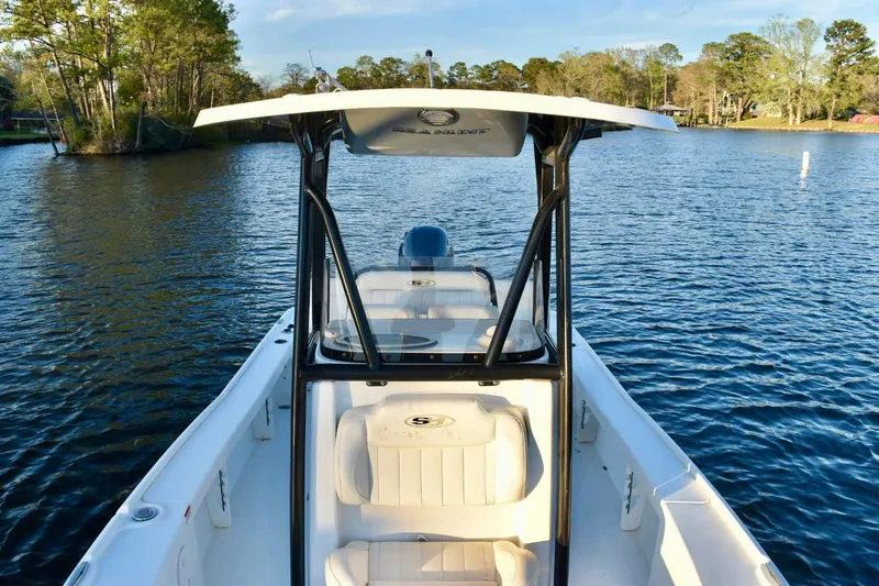 Slide: The Image of 2019 Sea Hunt BX 22 BR boat on a serene lake with lush trees in the background. - 7