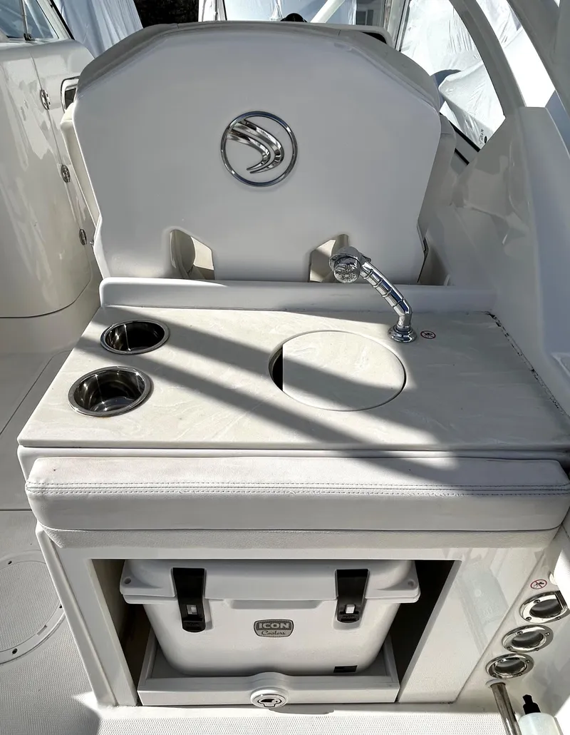 Slide: The Image of Edgewater 348 CX 2020 boat interior with sink, cup holders, and cooler storage. - 14