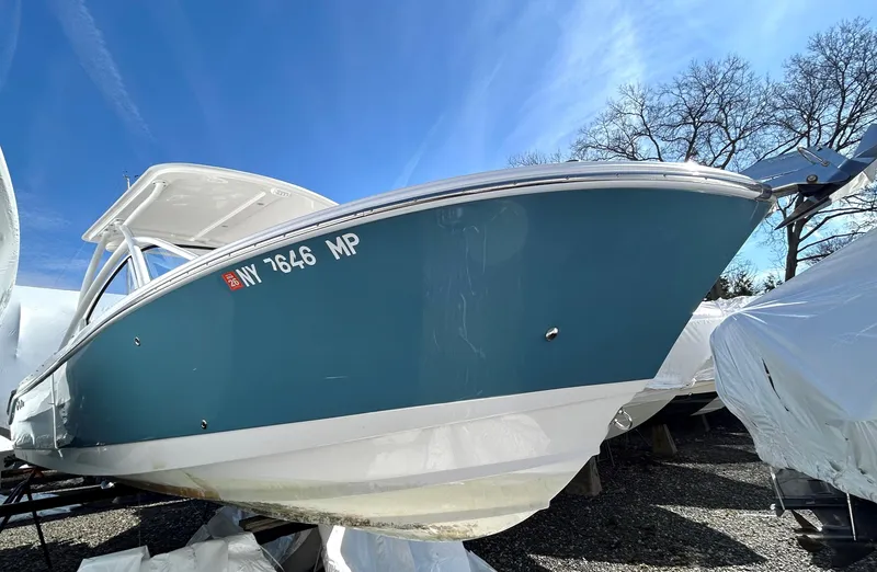 Slide: The Image of 2020 Edgewater 348 CX boat with blue hull, docked under clear sky. - 3