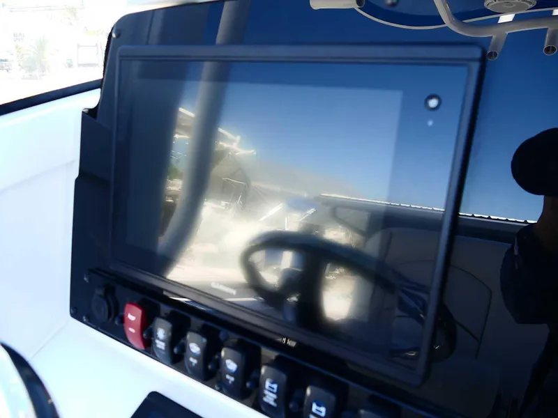 Slide: The Image of 2021 Sea Hunt Gamefish 27 dashboard with touchscreen and control switches. - 16