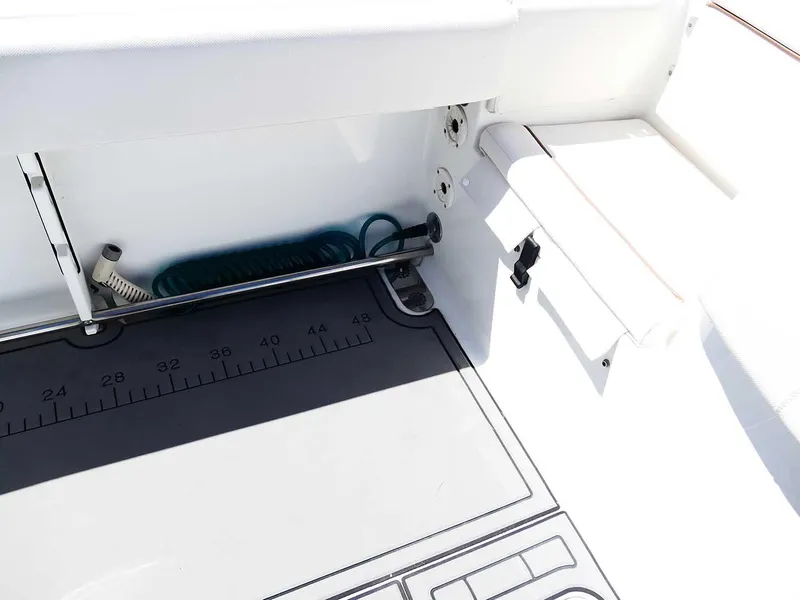 Slide: The Image of 2021 Sea Hunt Gamefish 27 interior, featuring a measuring mat and storage area. - 44