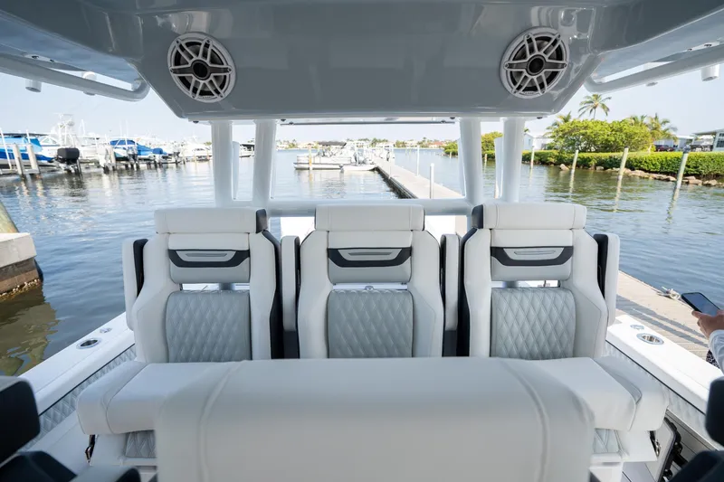 Slide: The Image of 2024 Blackfin 400 CC boat interior with luxurious seating at a marina. - 24