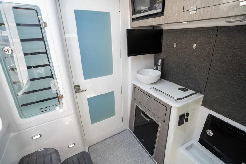 Slide: The Image of 2024 Blackfin 400 CC interior with modern kitchenette and sleek design. - 32