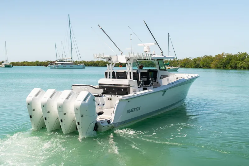 Slide: The Image of 2024 Blackfin 400 CC boat with four engines cruising on clear water. - 4