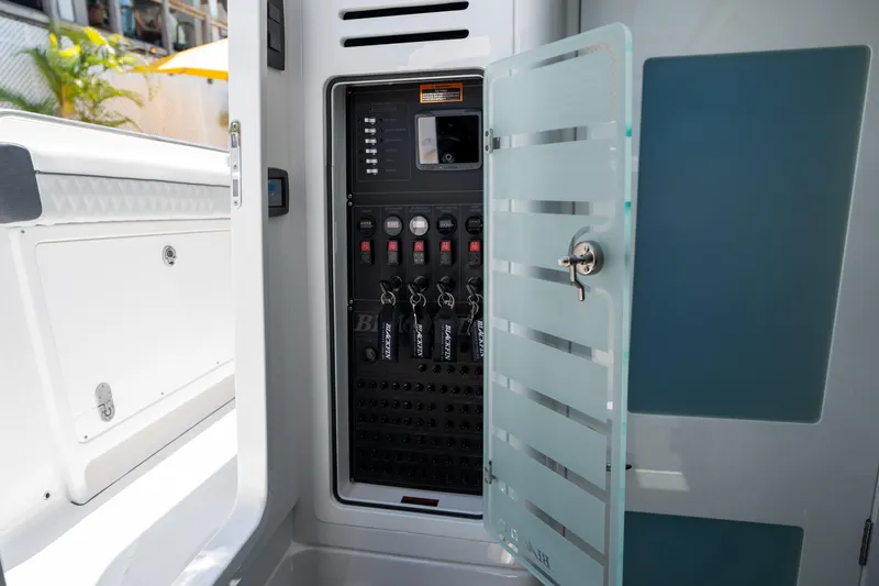 Slide: The Image of 2024 Blackfin 400 CC electrical panel with open glass door, showcasing controls and switches. - 40