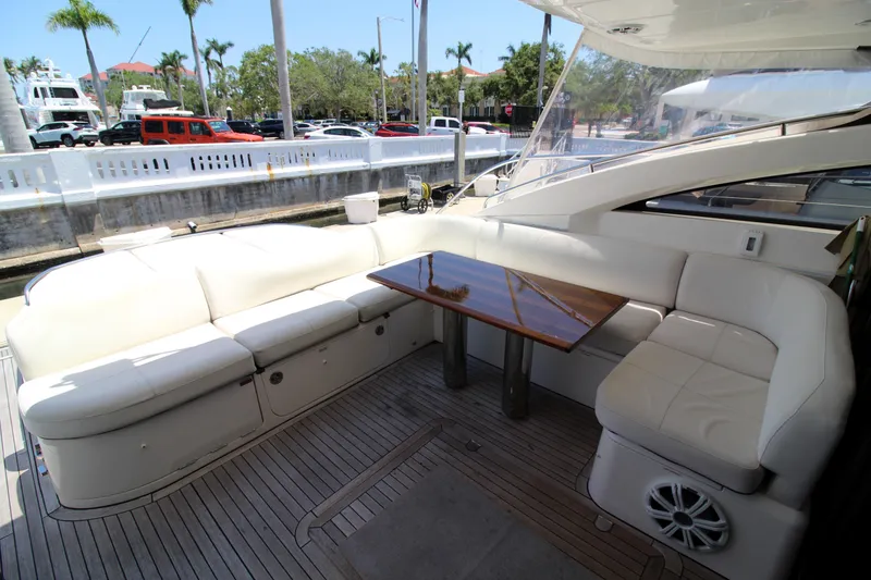 Slide: The Image of Luxurious seating area on 2013 Princess V62 yacht with wooden table and white cushions. - 2