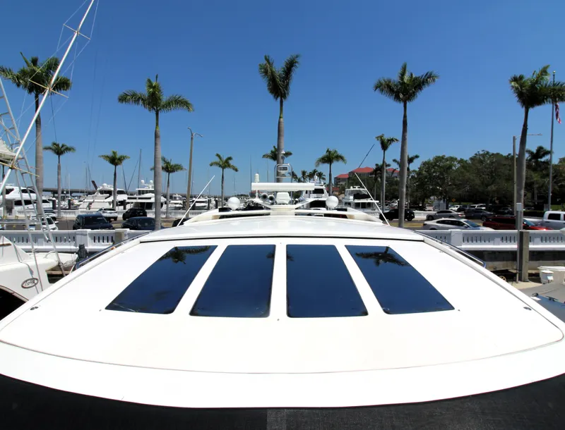 Slide: The Image of 2013 Princess V62 yacht with sunroof, docked at marina under clear blue sky. - 34