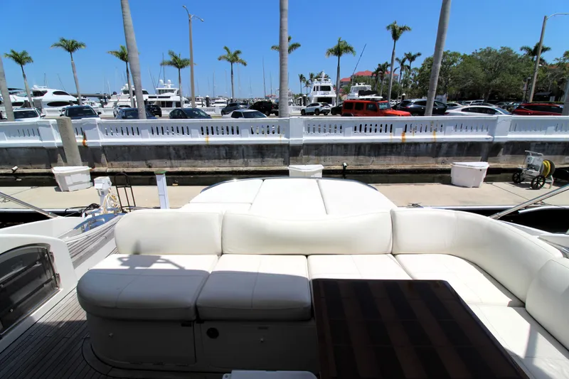 Slide: The Image of Luxurious 2013 Princess V62 yacht with elegant seating, docked near palm trees and parked cars. - 42