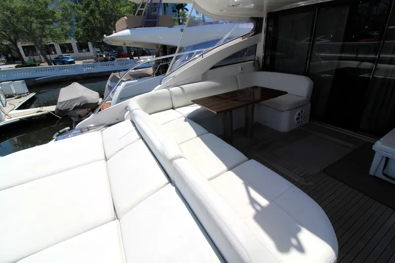 Slide: The Image of Luxurious 2013 Princess V62 yacht with spacious white seating and wooden table on deck. - 43