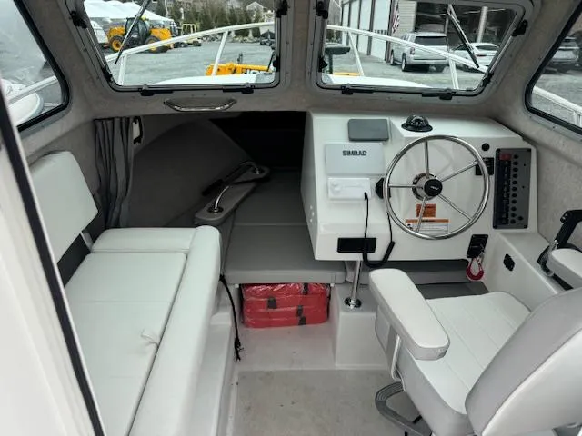 Slide: The Image of Interior of a 2022 Parker 2120 Sport Cabin boat with steering wheel and seating. - 3