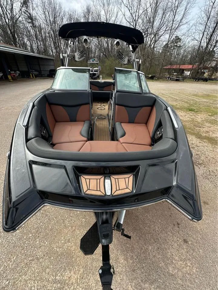 Slide: The Image of 2021 MasterCraft XT22 boat with sleek design and spacious seating, parked outdoors. - 9