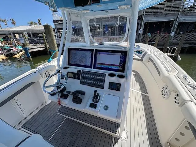 Slide: The Image of 2019 Tidewater 320 CC Adventure boat cockpit with dual screens and steering wheel. - 11
