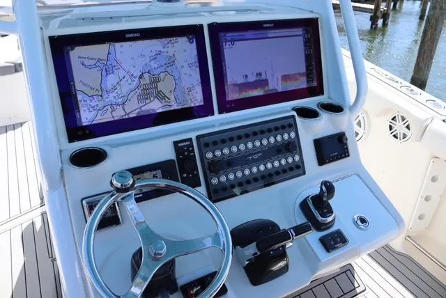 Slide: The Image of 2019 Tidewater 320 CC Adventure boat dashboard with navigation screens and controls. - 12