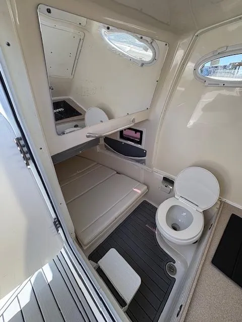 Slide: The Image of 2019 Tidewater 320 CC Adventure boat cabin with toilet and seating area. - 15