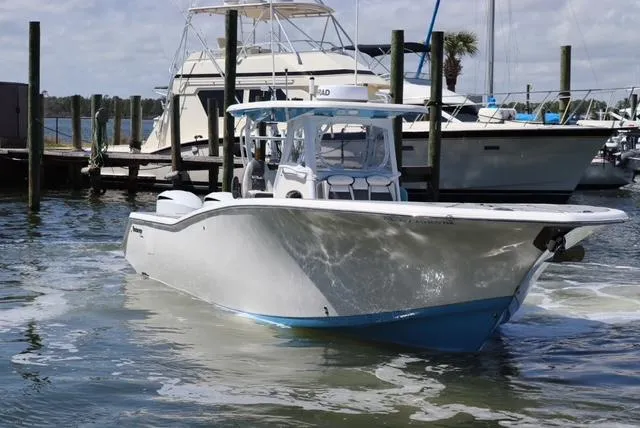 Slide: The Image of 2019 Tidewater 320 CC Adventure boat docked in a marina. - 2