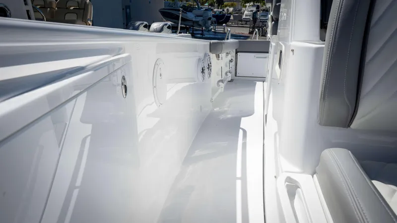 Slide: The Image of 2025 Everglades 335 CC boat interior, featuring sleek white design and comfortable seating. - 12