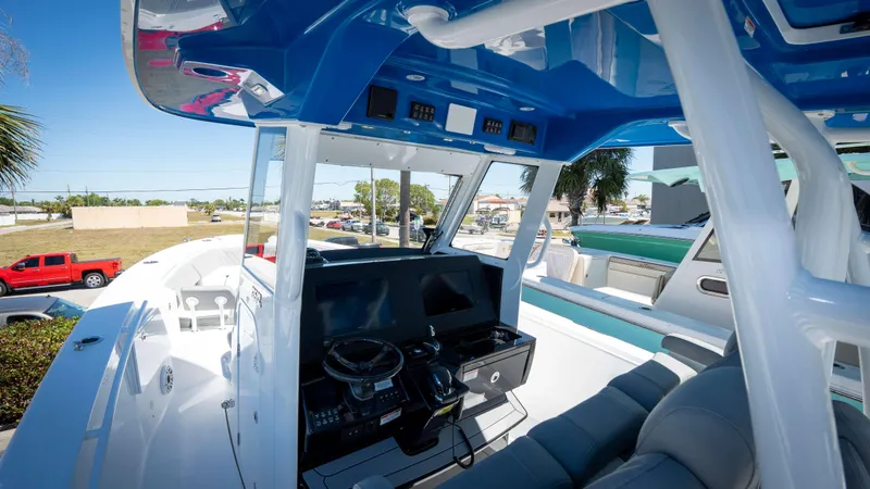 Slide: The Image of 2025 Everglades 335 CC boat cockpit with modern controls and blue canopy. - 19