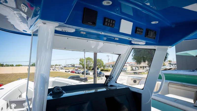 Slide: The Image of 2025 Everglades 335 CC boat cockpit with blue canopy and modern controls. - 21