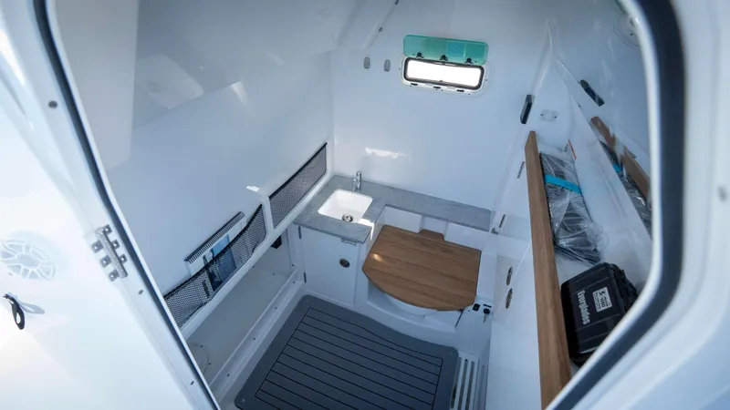 Slide: The Image of Interior of 2025 Everglades 335 CC boat, featuring compact sink and wooden accents. - 24