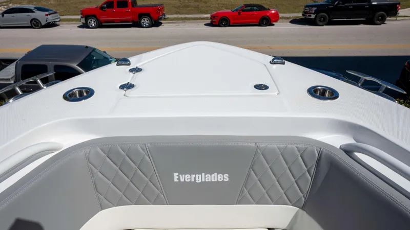 Slide: The Image of Bow view of 2025 Everglades 335 CC boat with gray seating and street background. - 31