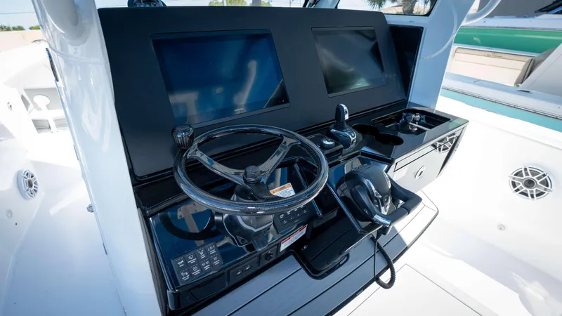 Slide: The Image of Control panel of 2025 Everglades 335 CC boat with dual screens and steering wheel. - 32