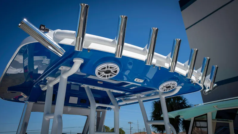 Slide: The Image of 2025 Everglades 335 CC boat with blue canopy and stainless steel rod holders. - 34