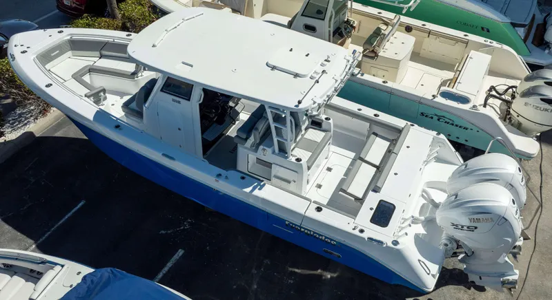 Slide: The Image of 2025 Everglades 335 CC boat with dual Yamaha engines, docked in a marina. - 4