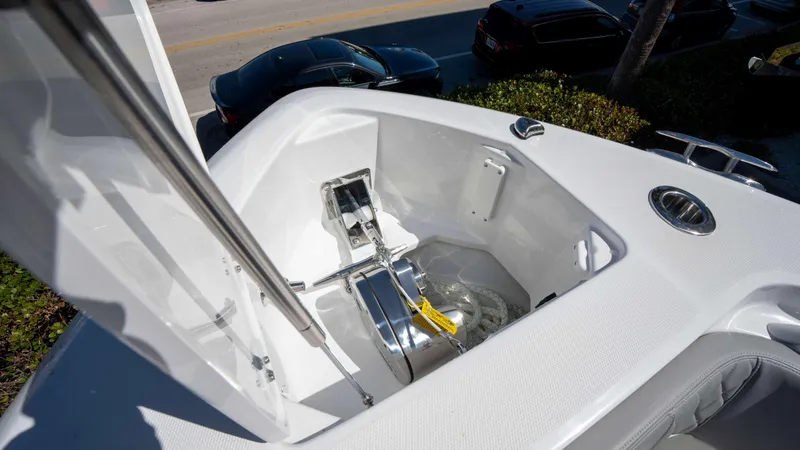 Slide: The Image of 2025 Everglades 335 CC boat anchor compartment with open hatch, showcasing storage and hardware. - 42